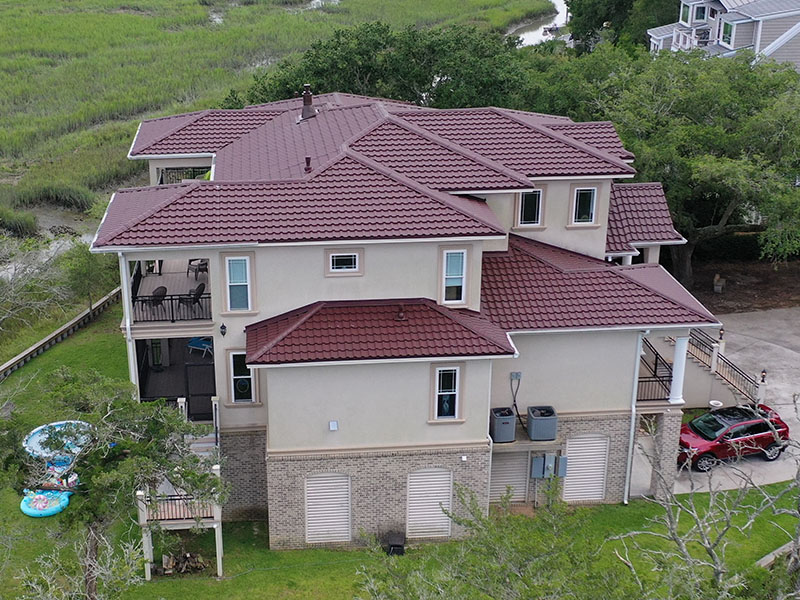 Side view of a home with a pink tiled roof by Tabor Homes & Exteriors