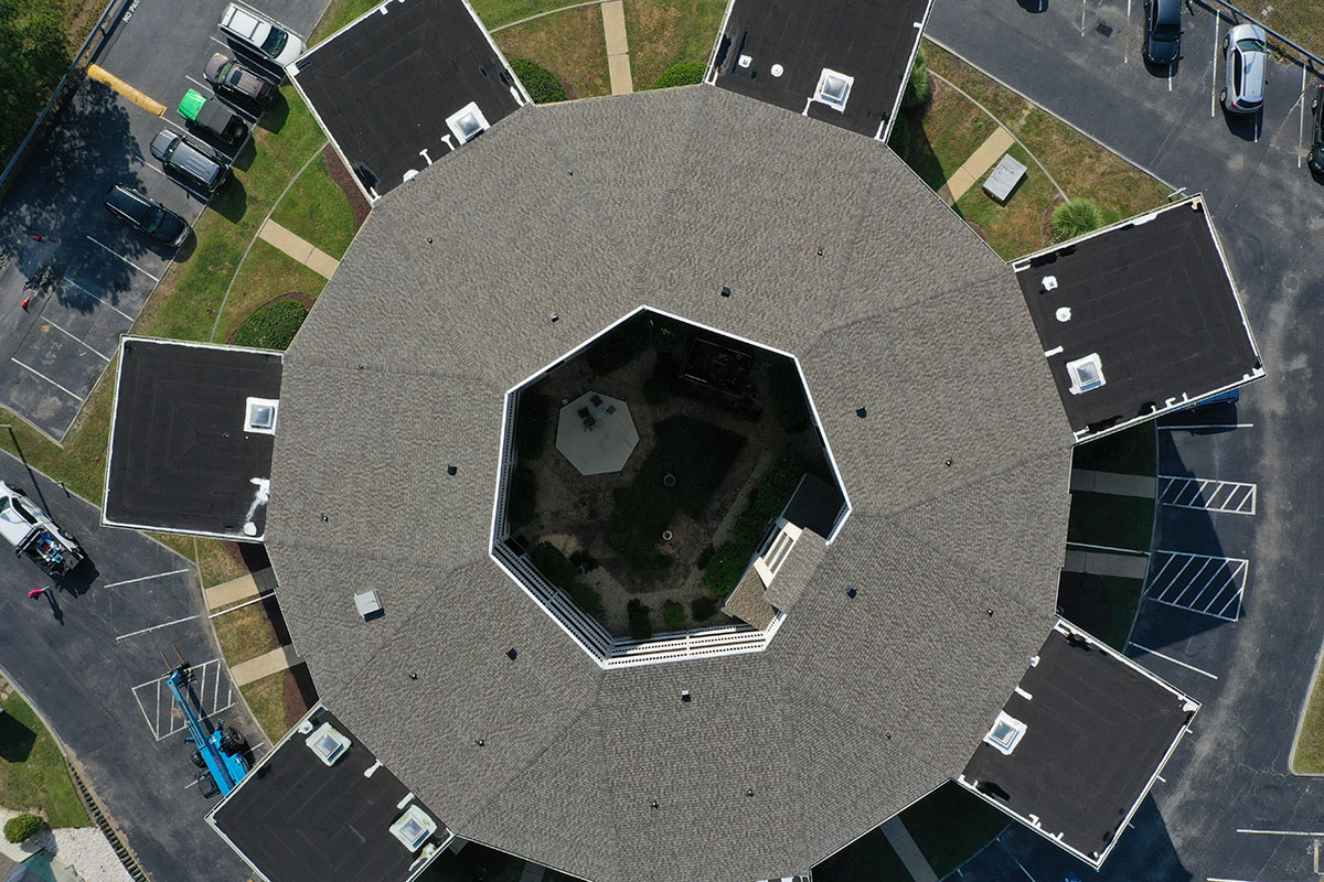 Top view of a circular shaped apartment complex with a roof made of gray shingles installed by Tabor Homes & Exteriors